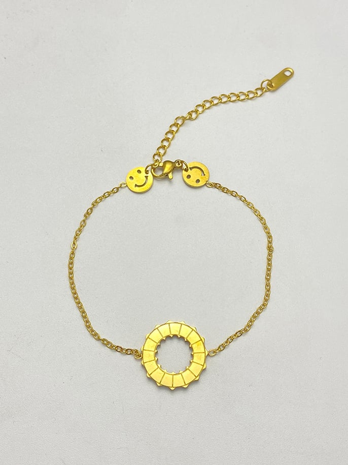 Golden Charm Bracelet with Smiley Faces and Rotating Ring, Adjustable for Casual Wear.