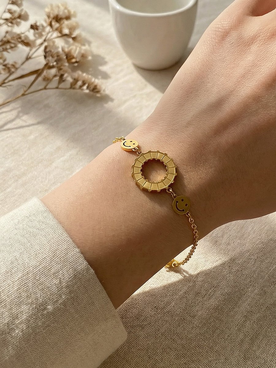 Golden Charm Bracelet with Smiley Faces and Rotating Ring, Adjustable for Casual Wear.