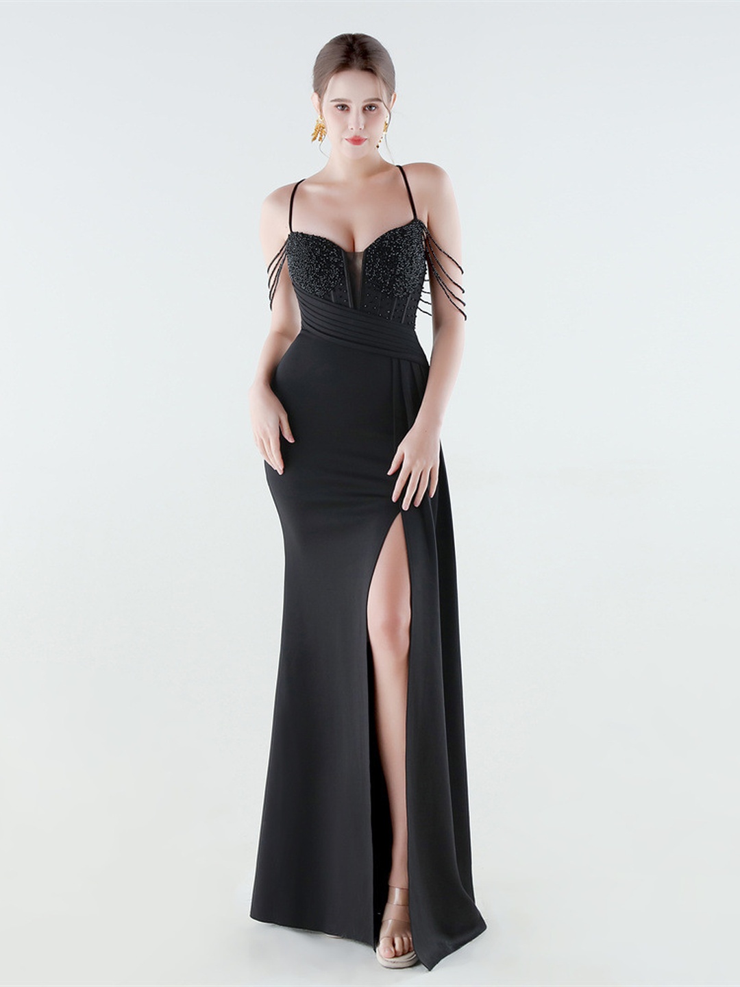 فستان سهرة بفتحة عالية وتصميم مكسر ومزين بالترتر بحمالات سباغيتي بلون أسود