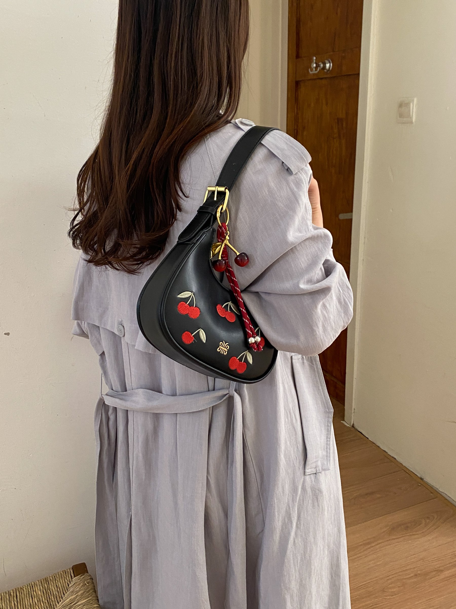 حقيبة كتف سوداء بمطرزات كرز