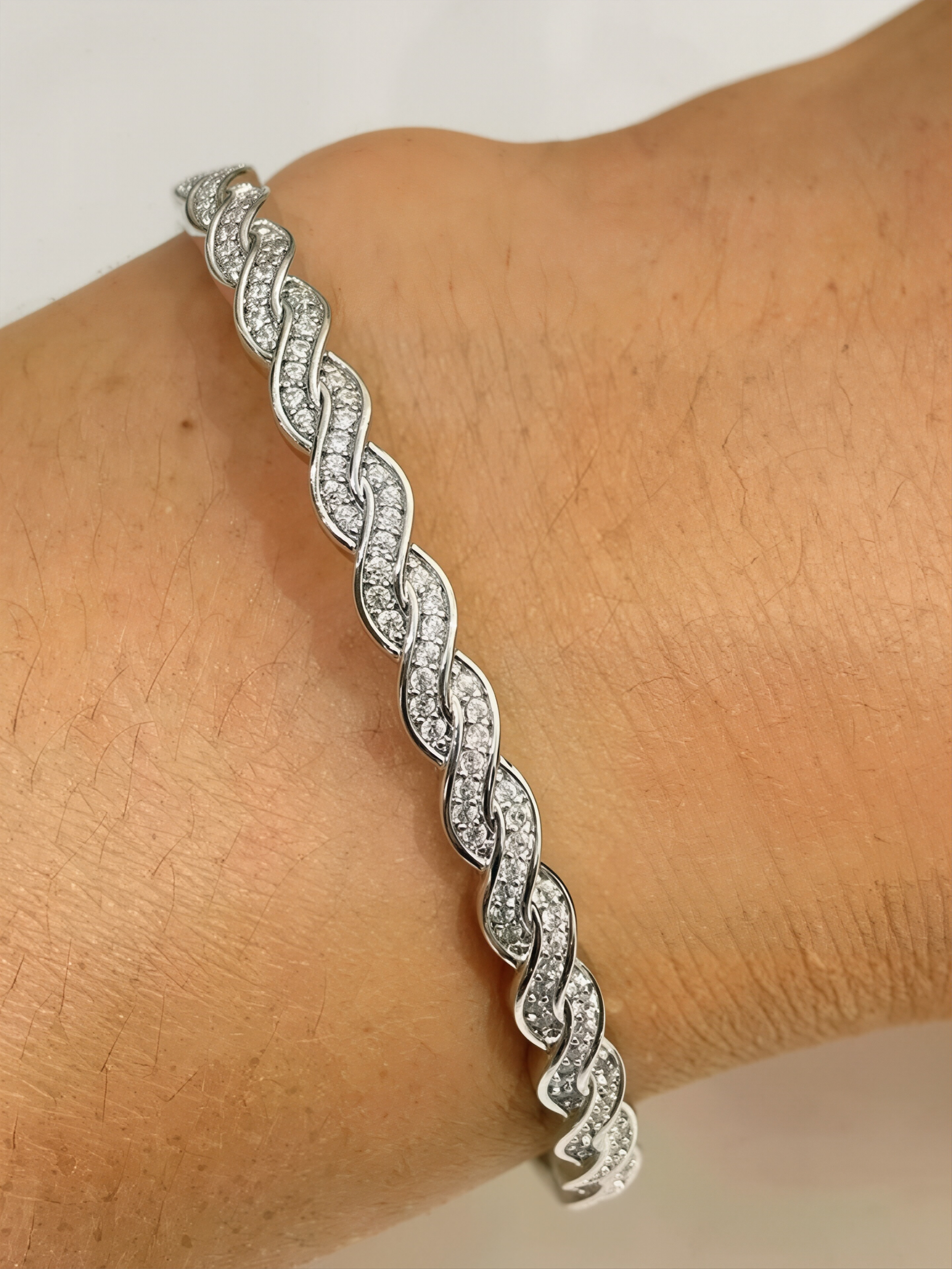 A silver twisted design ladies bracelet set with ultra-shiny cubic zirconia, perfect for parties and dinners