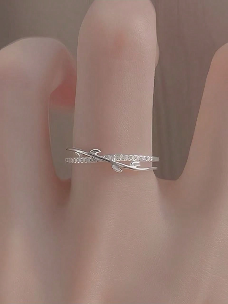 Simple cross-leaf ring, set with diamond branches, a womans daily wear accessory.